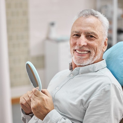 A happy, elderly man sitting in a dental chair
