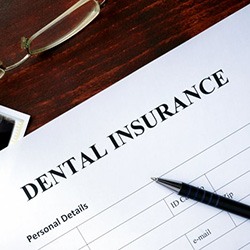 Dental insurance form sitting on a wood desk