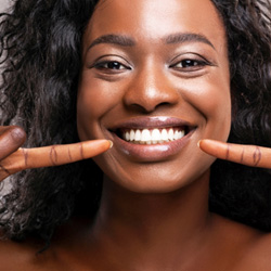 Woman pointing to her new smile 