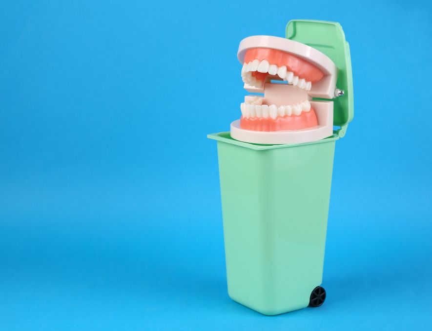 Fake teeth being put in a trash can